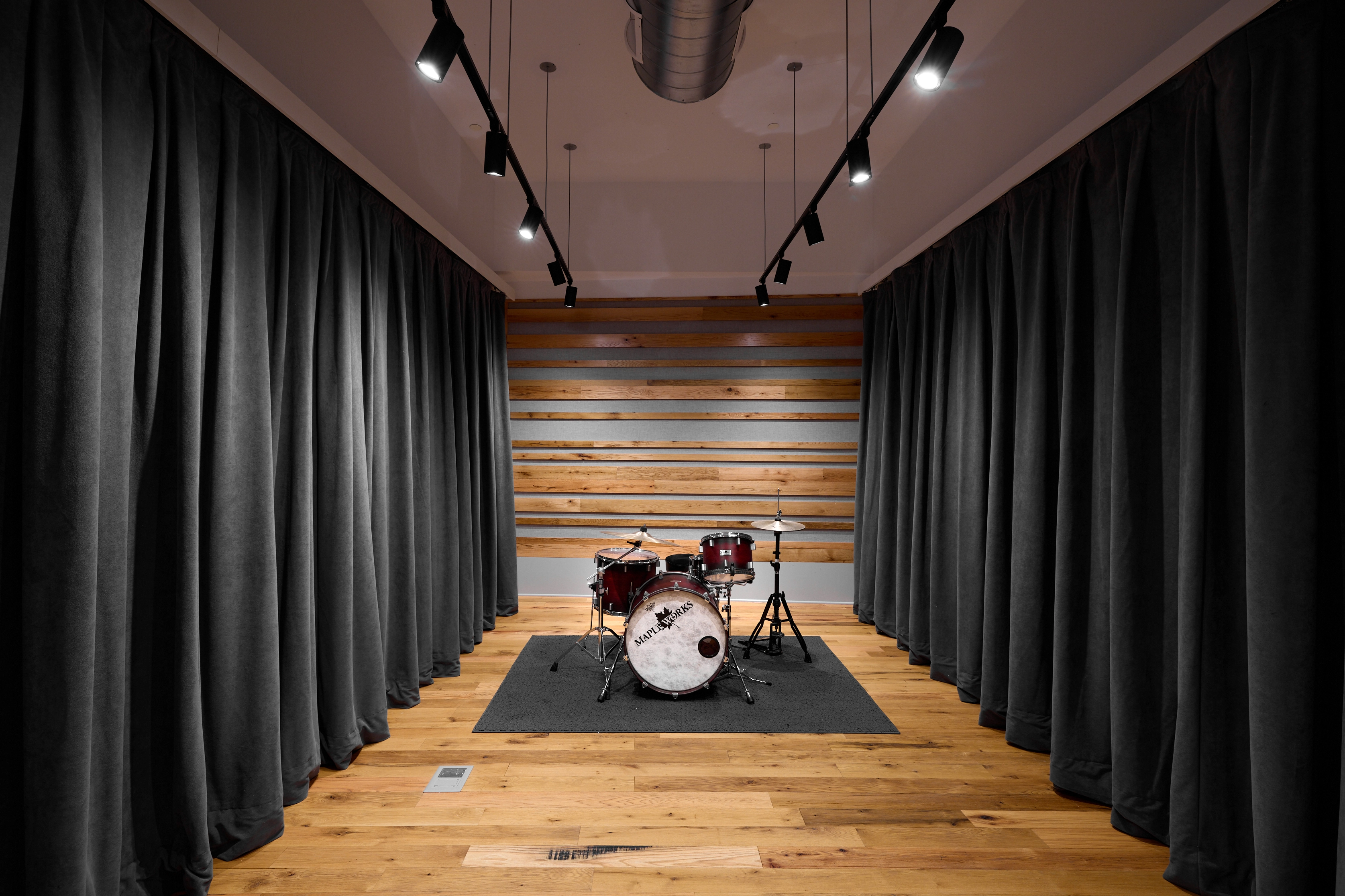 Studio B live room with curtained walls and drumset
